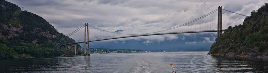 Norway Coast Fjord view from boat on ocean. Mountains, forests, waterfalls and small towns. Scandinavia, Norway