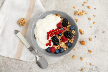 Bowl of tasty granola with yogurt and different berries on grunge background