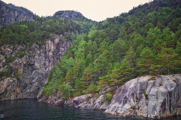 Norway Coast Fjord view from boat on ocean. Mountains, forests, waterfalls and small towns. Scandinavia, Norway