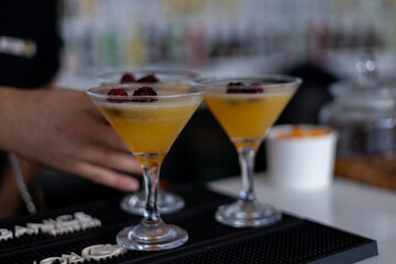 Brightly colored cocktails with fresh fruit garnishes at a vibrant bar setting