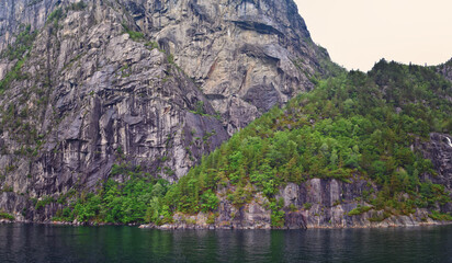 Norway Coast Fjord view from boat on ocean. Mountains, forests, waterfalls and small towns. Scandinavia, Norway