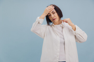 Mature Woman Suffering From Headache and High Fever on Blue Background