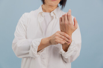 Female suffering from wrist pain is holding her aching joint