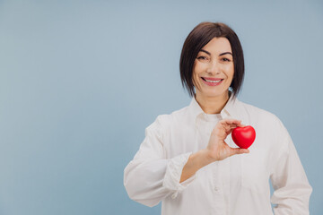 Middle aged woman showing red heart promoting cardiovascular health and disease prevention