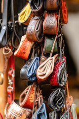 A collection of leather purses hanging on a rack
