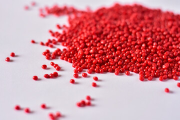 Red masterbatch granules on white background,color pigment carrier polymer in plastic...