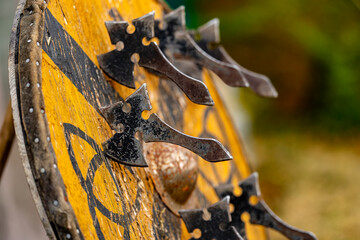 A group of axes are hanging from a wooden shield