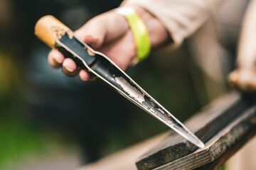 A person is holding a knife with a wooden handle
