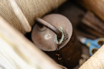 A rusty metal object with a chain hanging from it