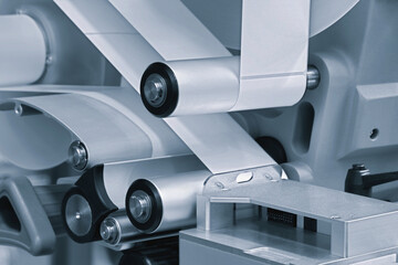 Fragment of the conveyor of sticking labeling machine. Abstract industrial background.