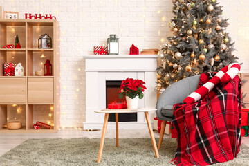 Armchair and coffee table with Christmas flower poinsettia in interior of living room