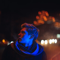 Young man posing under vibrant neon lights with futuristic streaks and a dramatic glow. Ideal for...