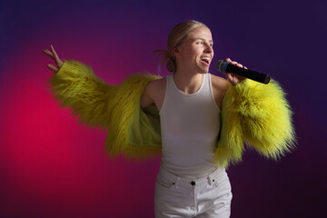 Talented singer in faux fur performing on purple background with pink light
