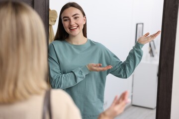 Happy woman welcoming guest to her apartment