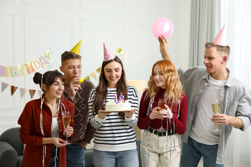 18th birthday. Group of happy friends with tasty cake having coming of age party at home