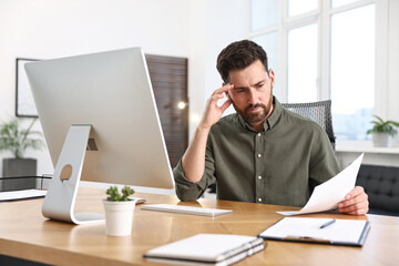 Man with document working at table in office © New Africa