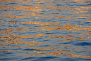 USA, California, Monterey. First light on calm waters and reflection of blue and gold just off of the Coast Guard Pier in Monterey Bay