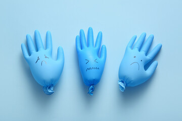 Gloves with sad faces on blue background. Blue Monday concept