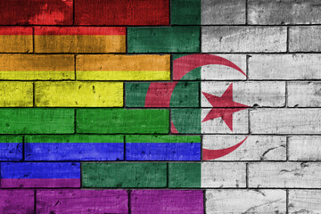 colourful painted big flag of algeria and rainbow gay pride flag on a massive old brick wall...
