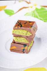 Dubai chocolate with pistachio filling on a white plate.