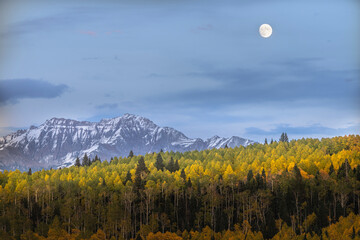 USA, Colorado, Uncompahgre National Forest. Full moon rises above aspen forest and mountains. © Danita Delimont
