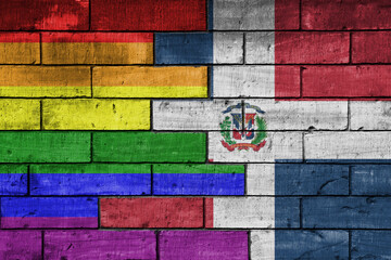 colourful painted big flag of dominican republic and rainbow gay pride flag on a massive old brick...