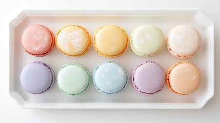 Obraz premium Colorful macarons arranged on a white rectangular plate.