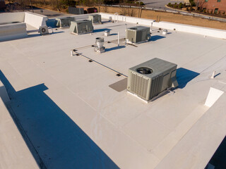 Fototapeta premium High Resolution Sunny Aerial Drone Image of a New TPO Roof on a Commercial Building With Visible HVAC Equipment: Roofing, HVAC, Architecture, Industry