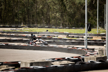 Teenage boy driving go kart around outdoor track
