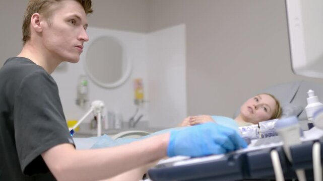 A gynecologist - ultrasound specialist performs an intervaginal ultrasound during a woman's appointment. Doctor shows an image of an early pregnancy on the ultrasound screen. IVF treatment protocols