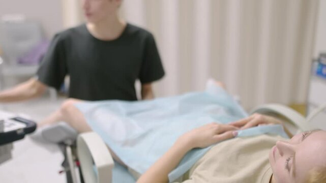 A gynecologist - ultrasound specialist performs an intervaginal ultrasound during a woman's appointment. Doctor shows an image of an early pregnancy on the ultrasound screen. IVF treatment protocols