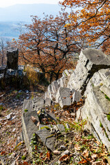 On a sunny autumn day, the landscape at Sedlo Mountain features vibrant foliage and rocky terrain, inviting exploration. The warmth of the sun enhances the beauty of the natural surroundings.