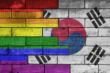 colourful painted big flag of south korea and rainbow gay pride flag on a massive old brick wall background. concept