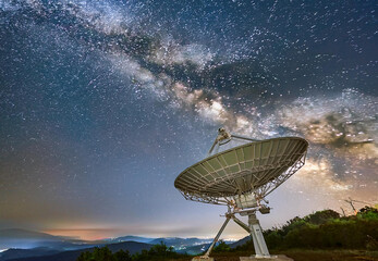 satellite dish against a night sky with milkyway