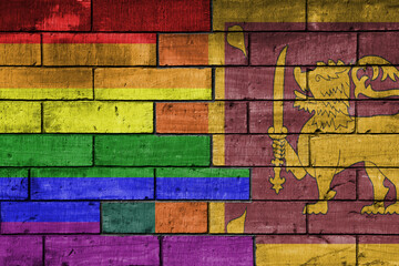 colourful painted big flag of sri lanka and rainbow gay pride flag on a massive old brick wall...