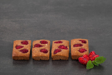 French cookie. Financier. Chocolate almond cookies with raspberries. Dark background. Copy space