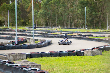 People driving go karts around outdoor track