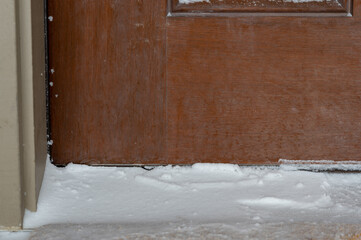 Building entrance with snow against the front door barrier.