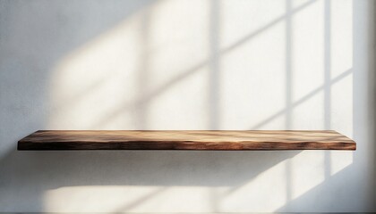 Empty wooden shelf against a white wall with sunlight streaming through a window.