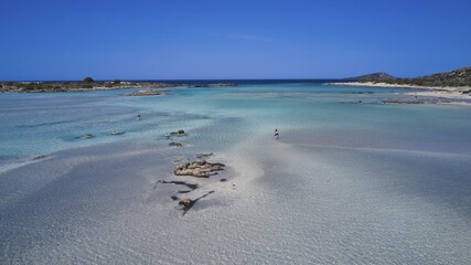 Clear sea water with stones and few people relaxing in the peaceful natural surroundings, Elafonissi, lagoon, south-west tip of Crete, Crete, Greek islands, Greece, Europe