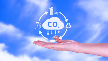 Hand holding CO2 reducing virtual icon for decrease carbon dioxide emission, carbon footprint and...