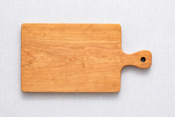 Handmade cherry wood chopping board. wooden cutting board. Empty cherry wood chopping board on sackcloth tabletop.
