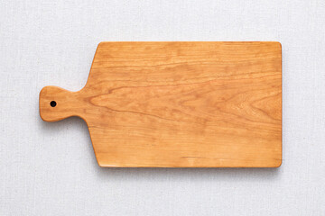 Handmade cherry wood chopping board. wooden cutting board. Empty cherry wood chopping board on sackcloth tabletop.