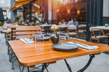 Outdoor empty coffee and restaurant terrace with potted plants tables and chairs in london indie and hipster style
