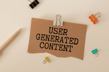Top view of pen,glasses and notebook written with User Generated Content
