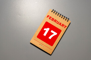 A close-up of a wooden block calendar displaying the date February 17