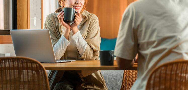 家・別荘・コテージでパソコンをやりながらコーヒーを飲む夫婦・カップル・男女(話す・会話)
