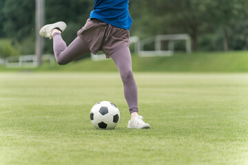 サッカーボールを蹴る・シュートする女性の足元

