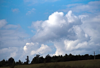 "Grzybowa" chmura - jak atomowa - nad lasem obok pola późnym latem. Błękitne niebo z chmurą, która wygląda trochę jak grzyb atomowy po wybuchu jądrowym. © Grzegorz