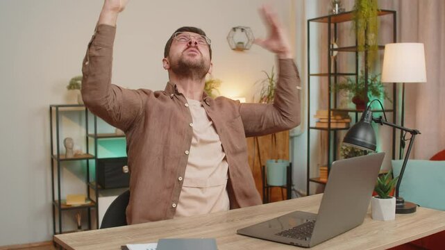 Caucasian young businessman freelancer shouting, trying not to hear the loud noise from neighbor apartment in building while they renovate home and he cant work on laptop netbook because of the noise.